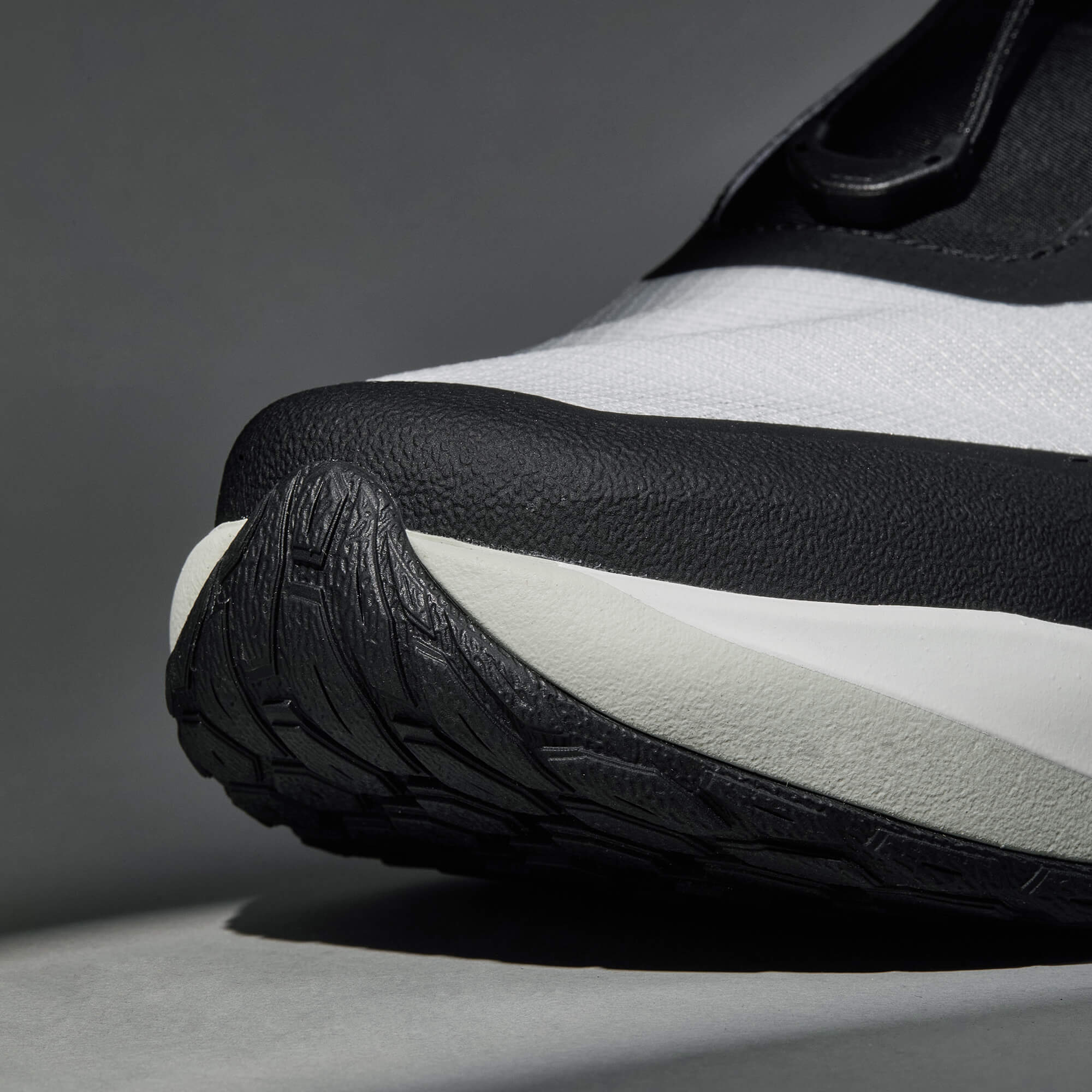 MUDDY VIBE S-16 Aurora White low-top hiking shoe with black accents, front view on a soft shadow background.