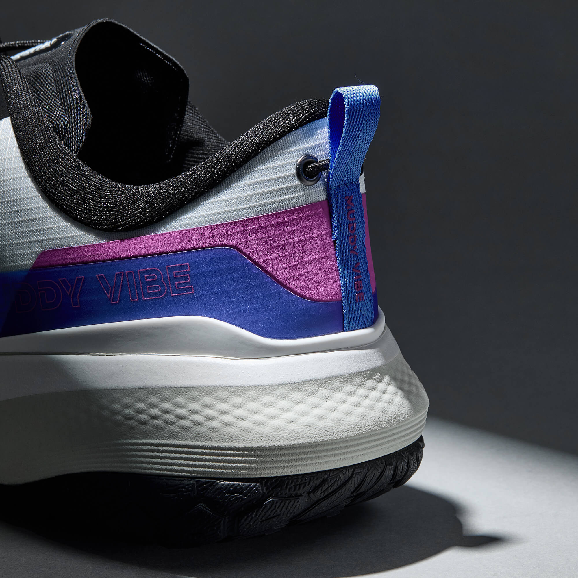 MUDDY VIBE S-16 Aurora White low-top hiking shoe with black, blue, and purple accents, heel detail view on a soft shadow background.