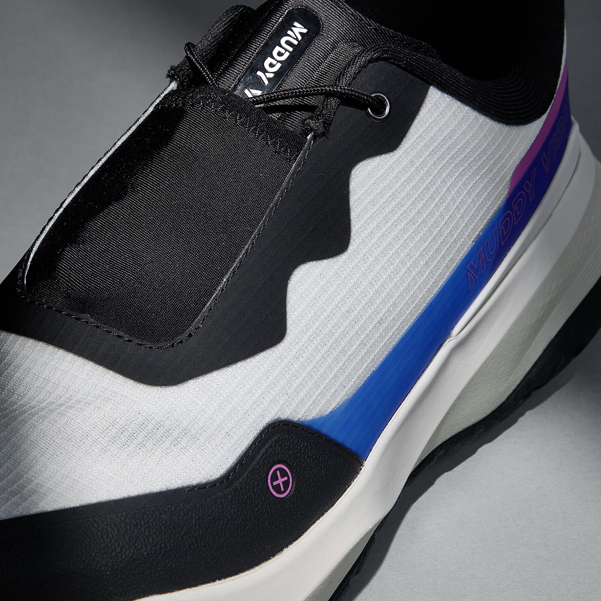 MUDDY VIBE S-16 Aurora White low-top hiking shoe with black, blue, and purple accents, laces view on a soft shadow background.