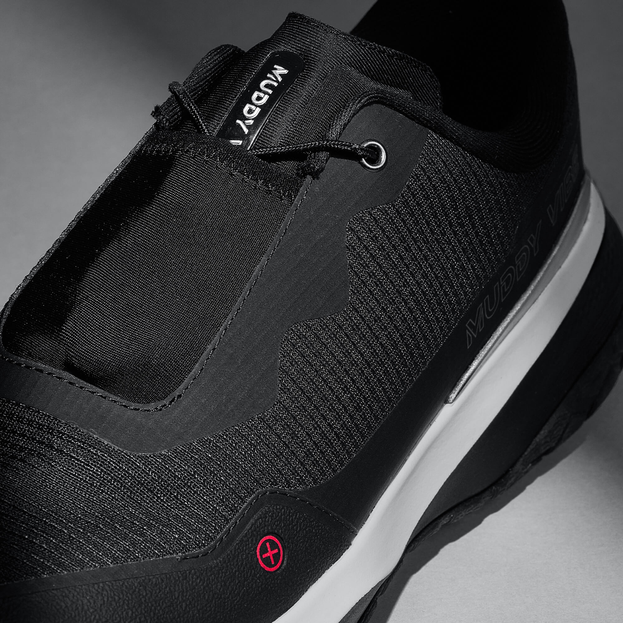 MUDDY VIBE S-16 Ridge Snow low-top hiking shoe with black and white accents, laces view on a soft shadow background.