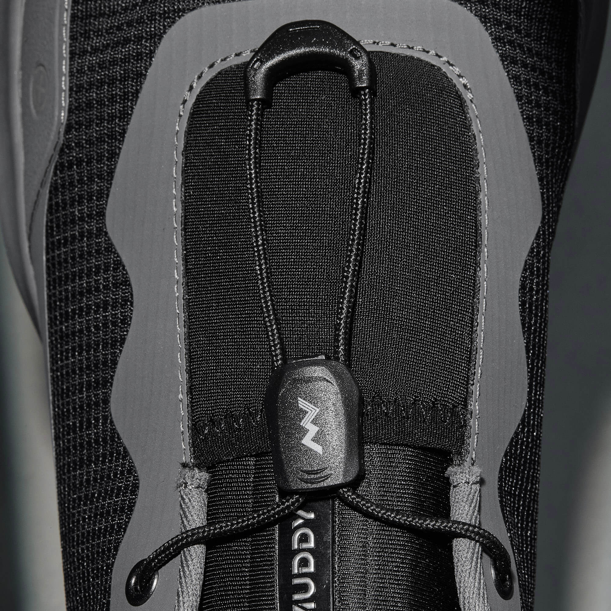 MUDDY VIBE S-16 Tide Rock low-top hiking shoe with black and grey accents, lace detail view on a soft shadow background.