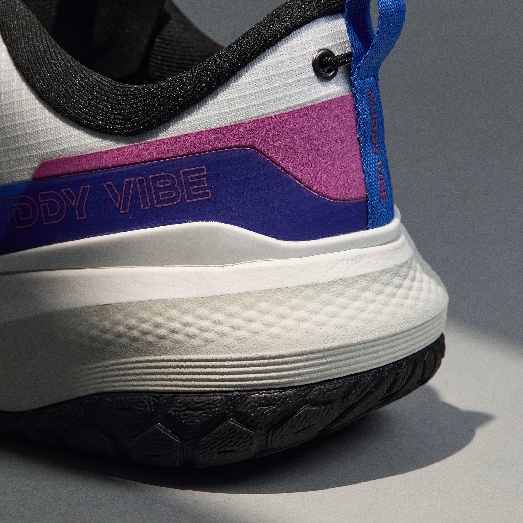 MUDDY VIBE Si-14 Aurora White low-top hiking shoe with black, blue, and purple accents, heel detail view on a soft shadow background.