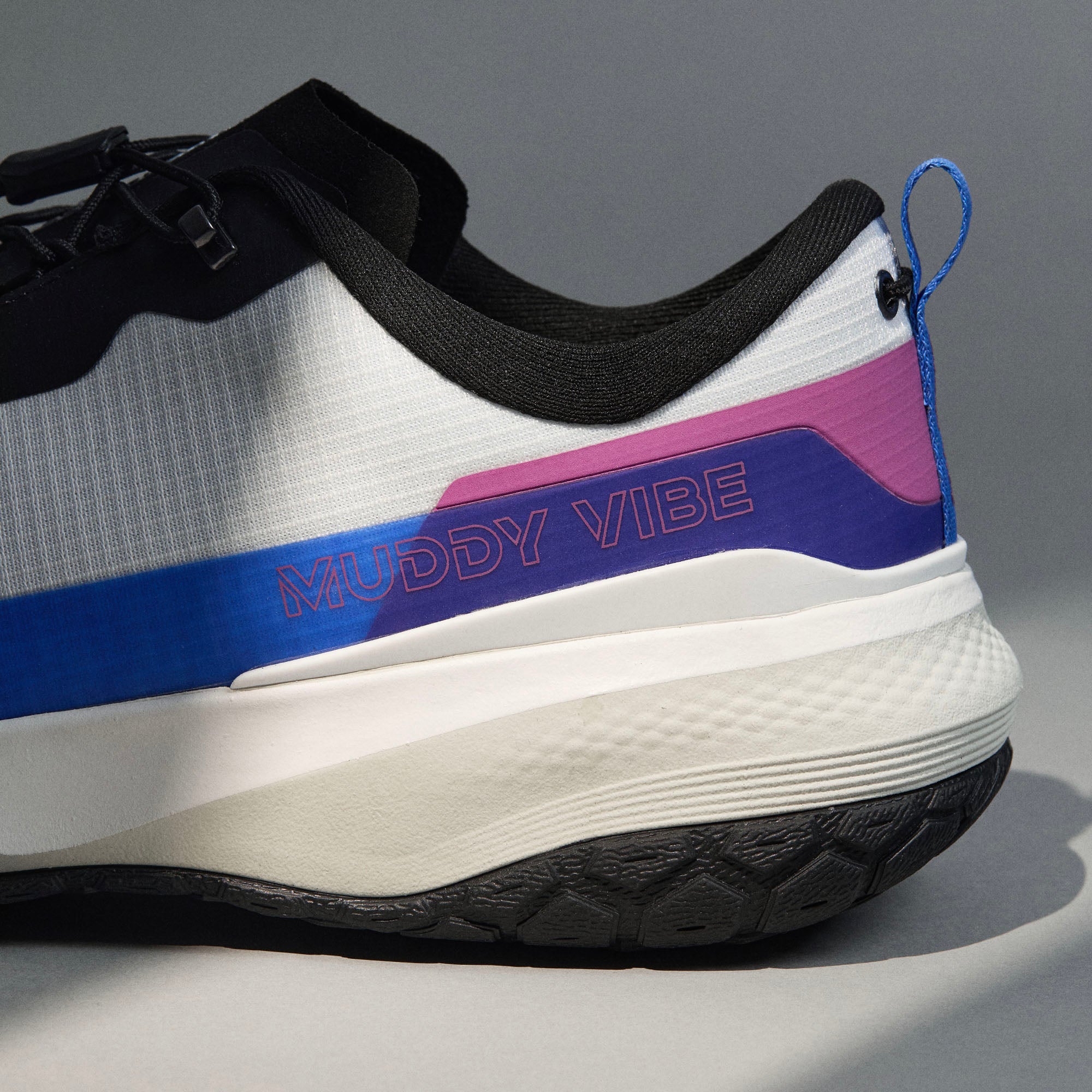 MUDDY VIBE Si-14 Aurora White low-top hiking shoe with black, blue, and purple accents, heel logo view on a soft shadow background.