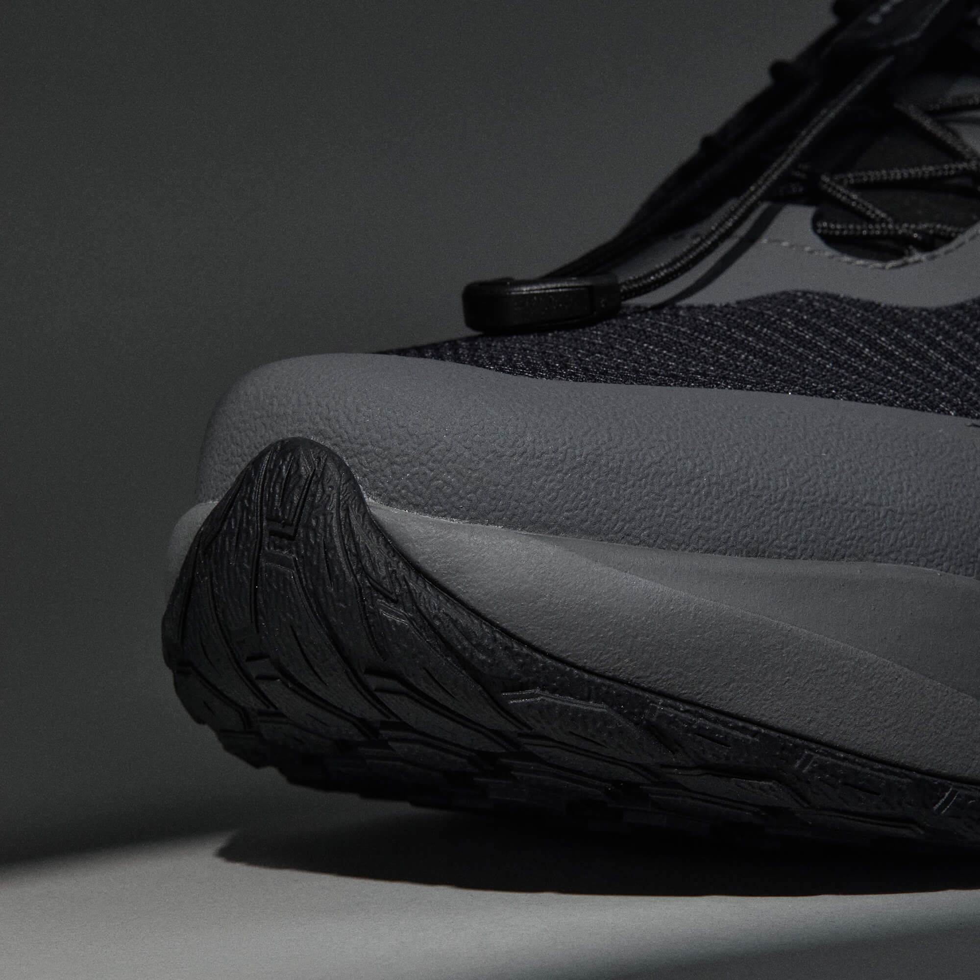 MUDDY VIBE Si-14 Tide Rock low-top hiking shoe with black and grey accents, front view on a soft shadow background.