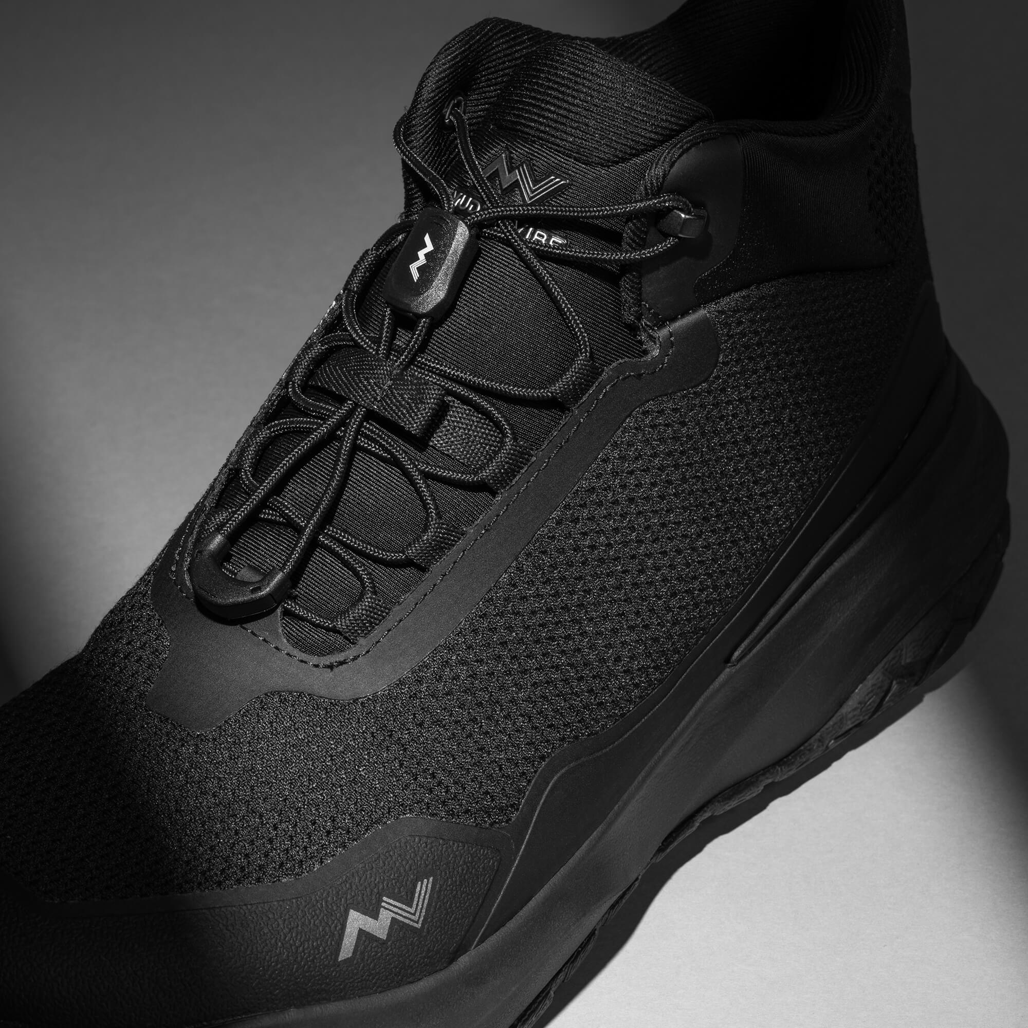 MUDDY VIBE Zn-30 Black Summit mid-top hiking shoe with with all-black trim, laces view on a soft shadow background.