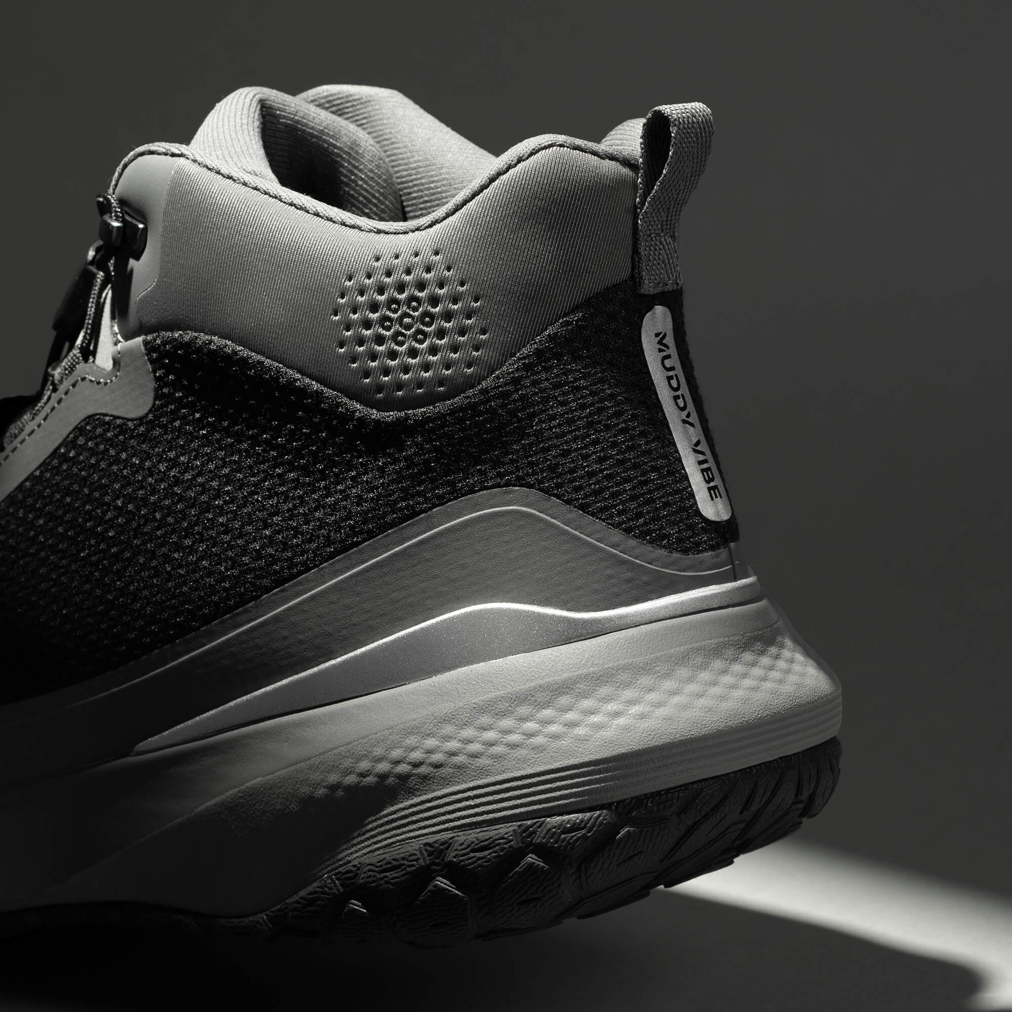 MUDDY VIBE Zn-30 Cliff Grey mid-top hiking shoe with black and white accents, heel detail view on a soft shadow background.