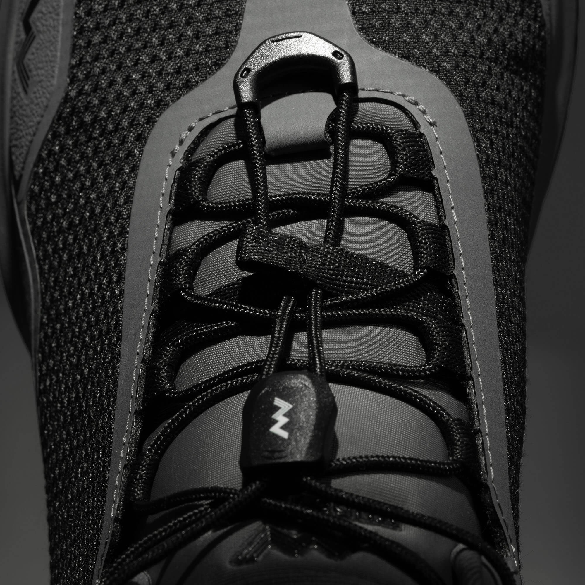 MUDDY VIBE Zn-30 Cliff Grey mid-top hiking shoe with black accents, laces detail view on a soft shadow background.