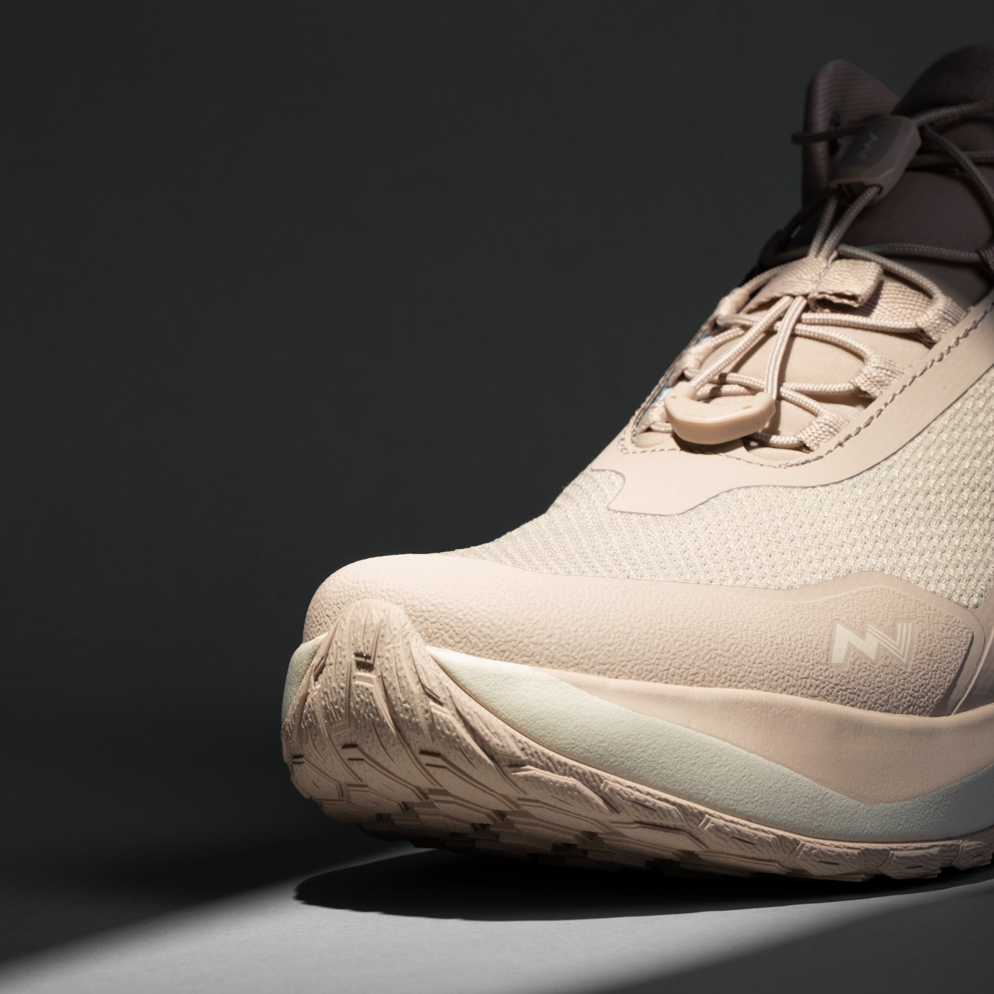 MUDDY VIBE Zn-30 Desert Sand mid-top hiking shoe with light beige and off-white accents, front view on a soft shadow background.