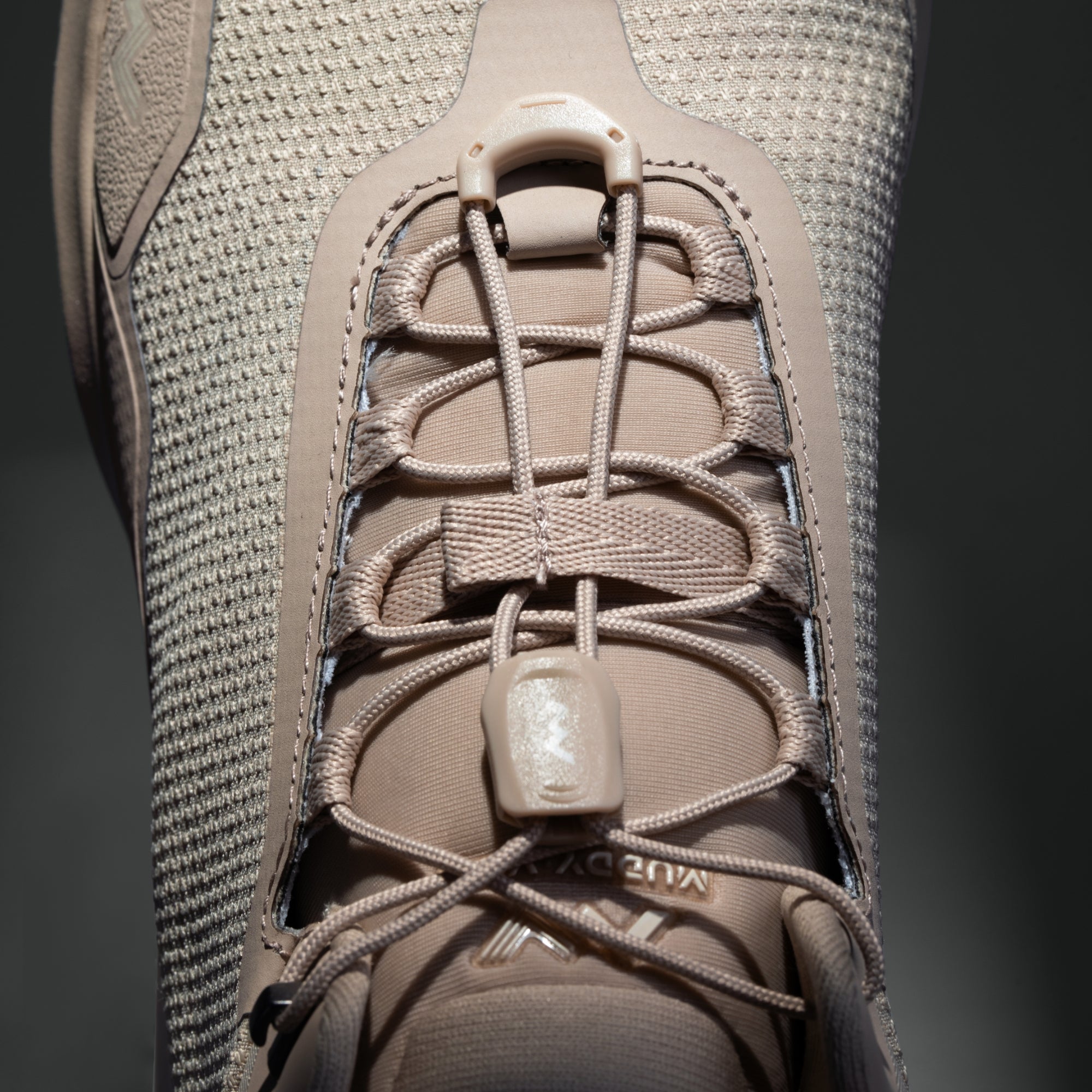 MUDDY VIBE Zn-30 Desert Sand mid-top hiking shoe with light beige and off-white accents, lace detail view on a soft shadow background.