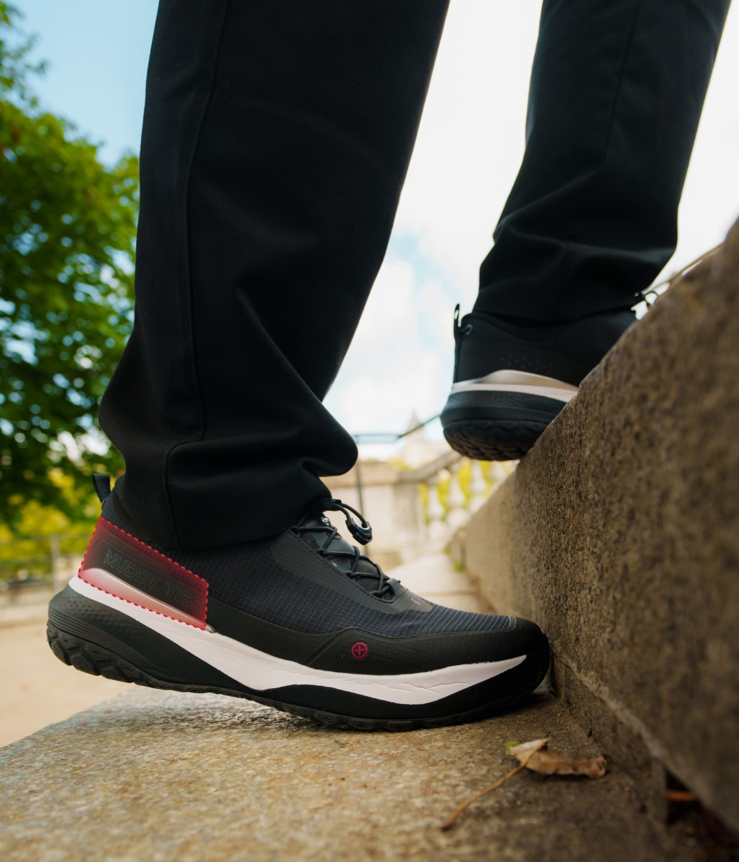 Si-14 lightweight black walking shoes showing support while climbing a step outdoors.